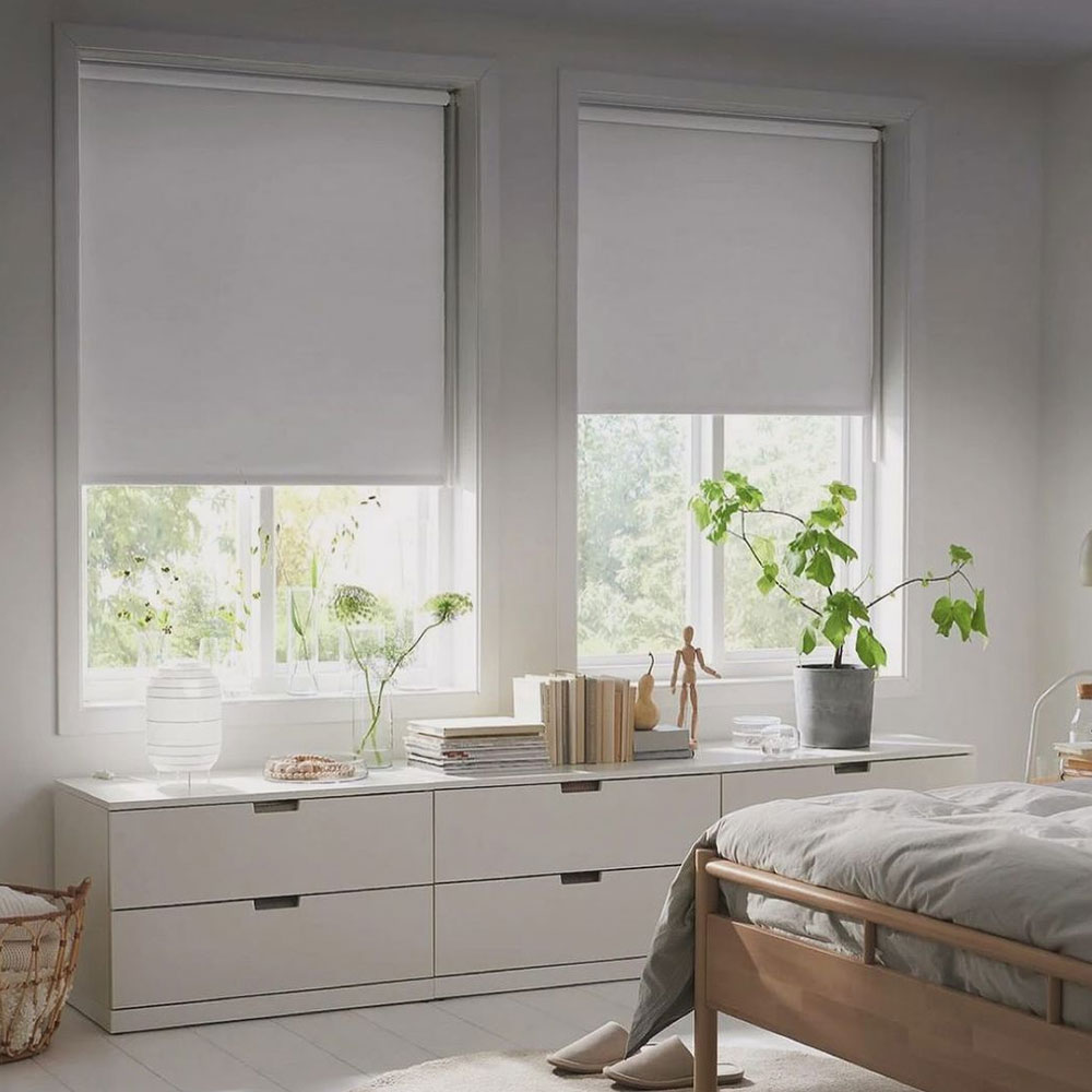 A room with FÖNSTERBLAD blinds halfway closed and a NORDLI chest of drawers.