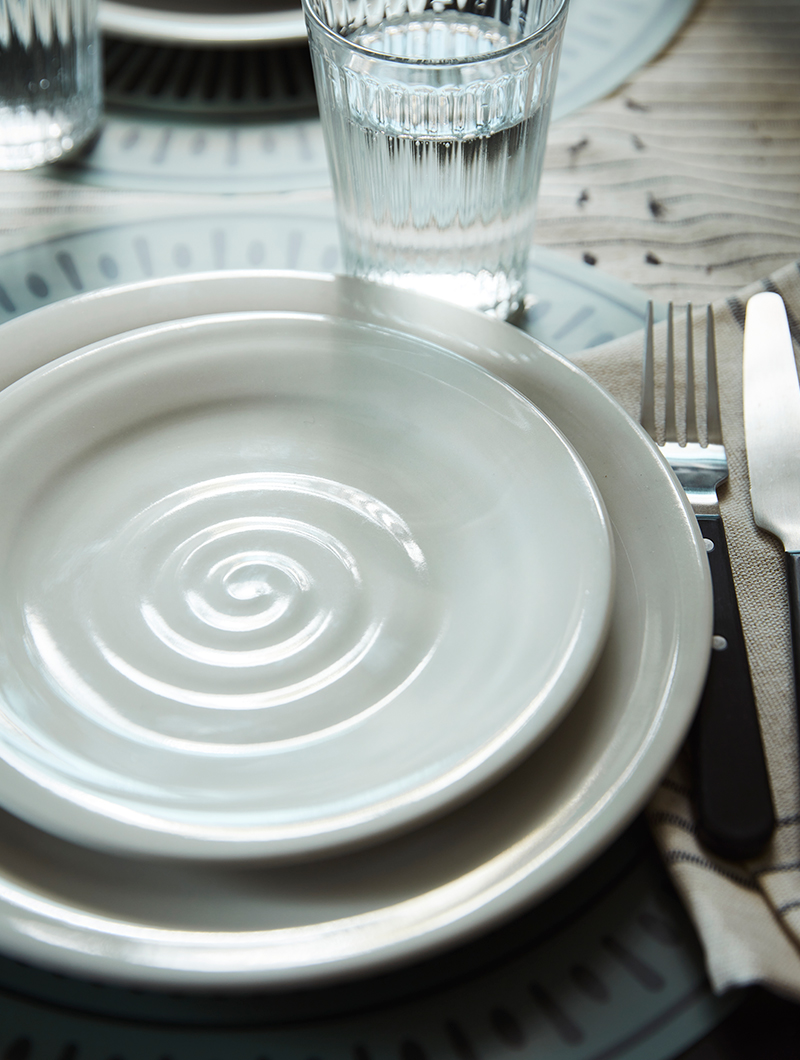 White tableware, with cutlery and glasses
