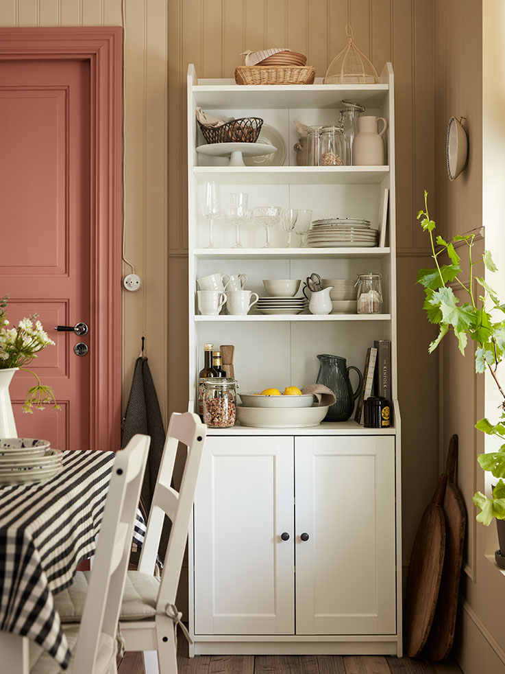Tall cabinet with shelves, lower doors, white vintage style, located in a corner.