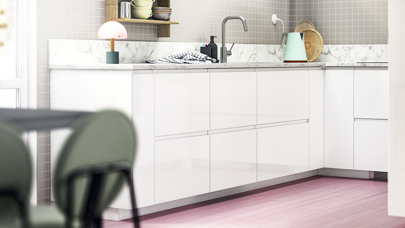 Modern kitchen with white cabinets, grey faucet, and accessories on marble countertop.