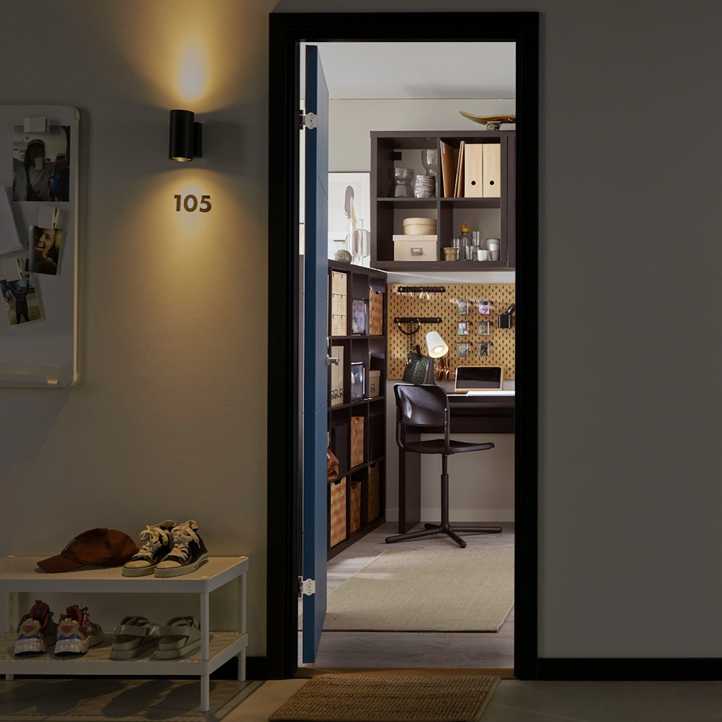  Dark hallway with two open doors. One to brown office, other to pink room. Contrasts.