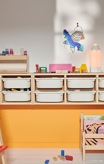  A TROFAST wall storage and a FLISAT book display in a room