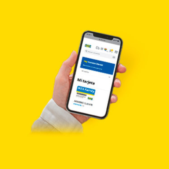 Mano sosteniendo un teléfono móvil con la tarjeta digital IKEA Family en pantalla.