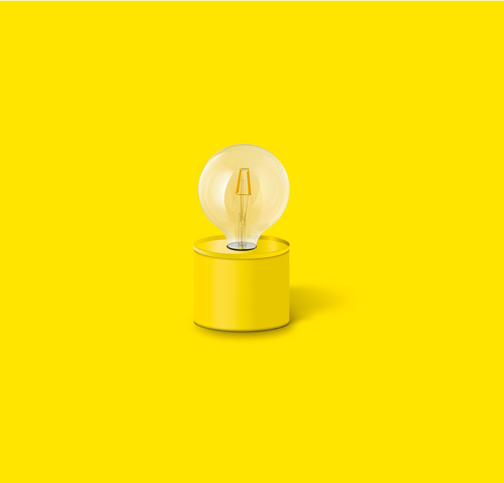 Lámpara de mesa amarilla con bombilla de filamento transparente sobre fondo amarillo.