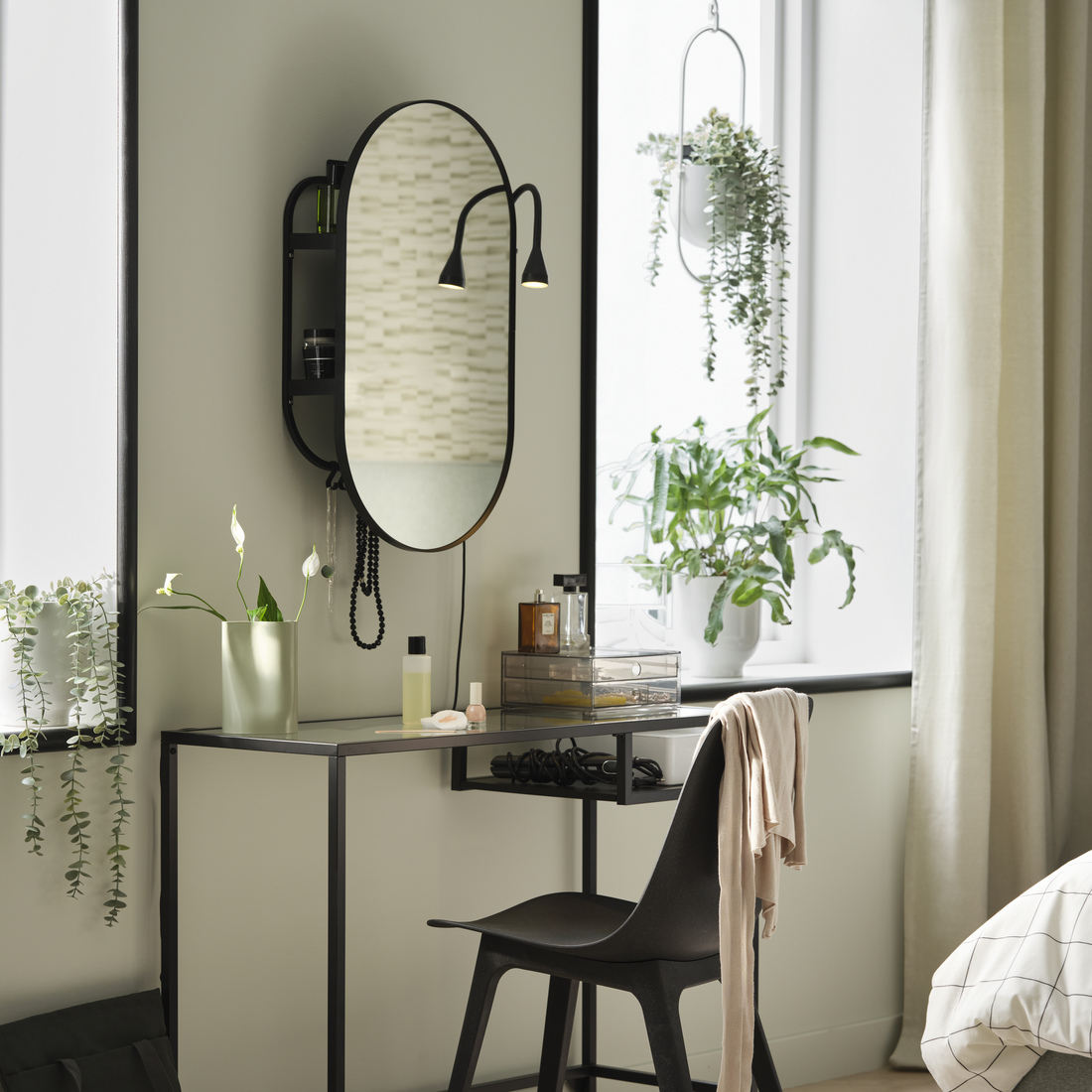 A bright room featuring a VITTSJÖ desk and an ODGER chair, with a LINDBYN mirror above and two DRÖMSK plant pots decorating the window to the right.