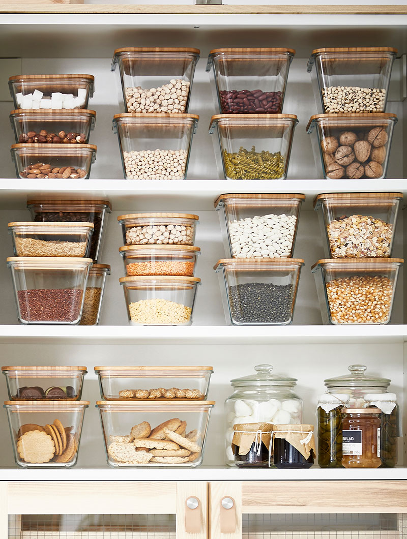Several IKEA 365+ Food containers on a kitchen cabinet