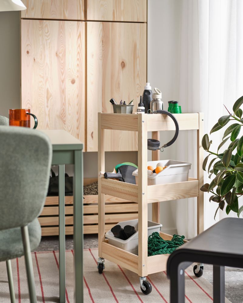 A light wood utility cart, organized with tools and supplies. Natural and warm tone.