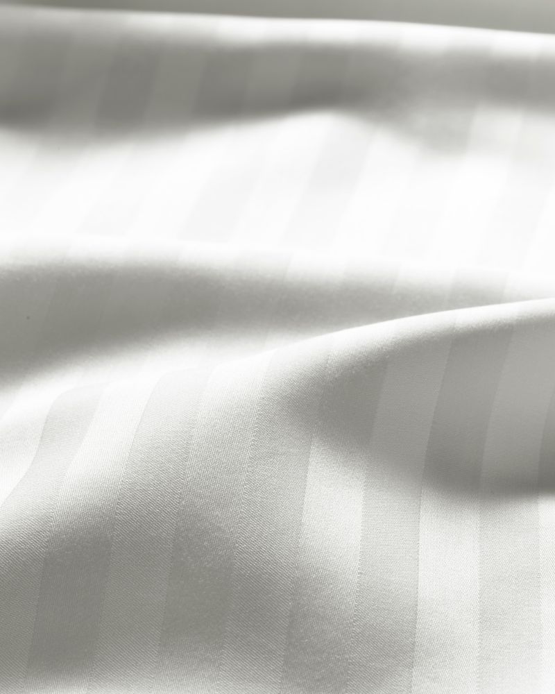 A close-up on white NATTJASMIN bed linen with a ripple in it to show the finish of the material.