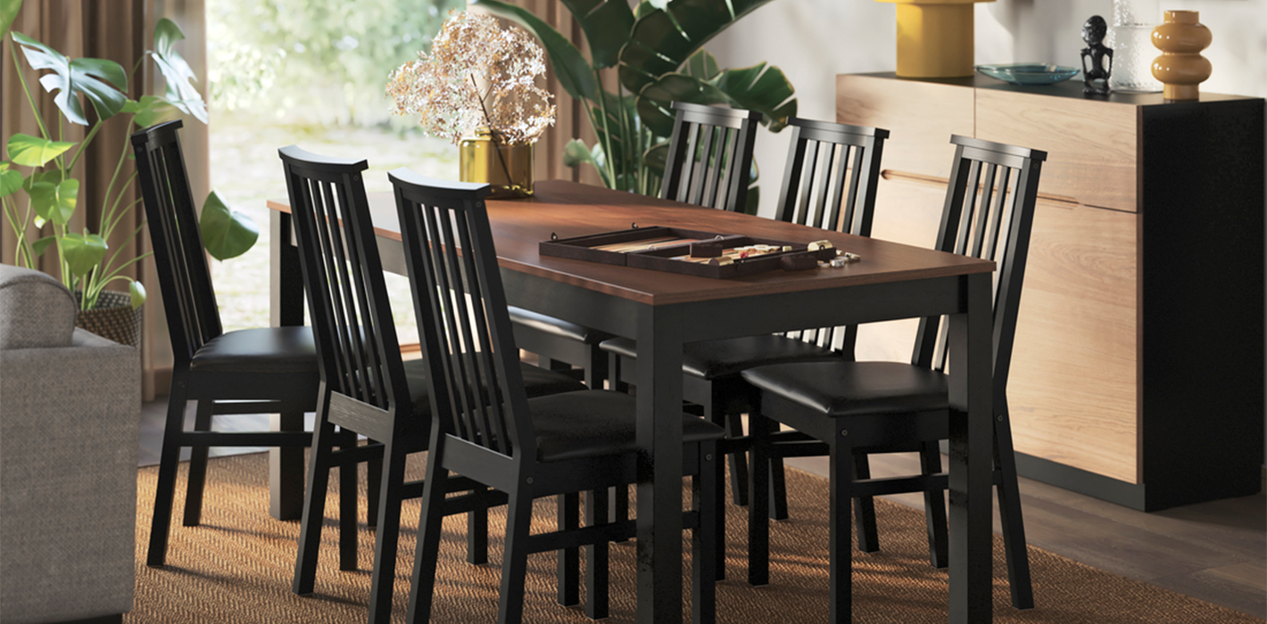 A dining area has a beige/brown ÅLHULT extendable table with a bench on one side and two chairs with soft seats on the other.