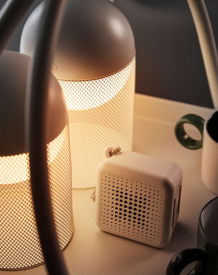 A close-up of white SOLVINDEN LED decoration lighting with a mesh design and battery-operated globe on a table