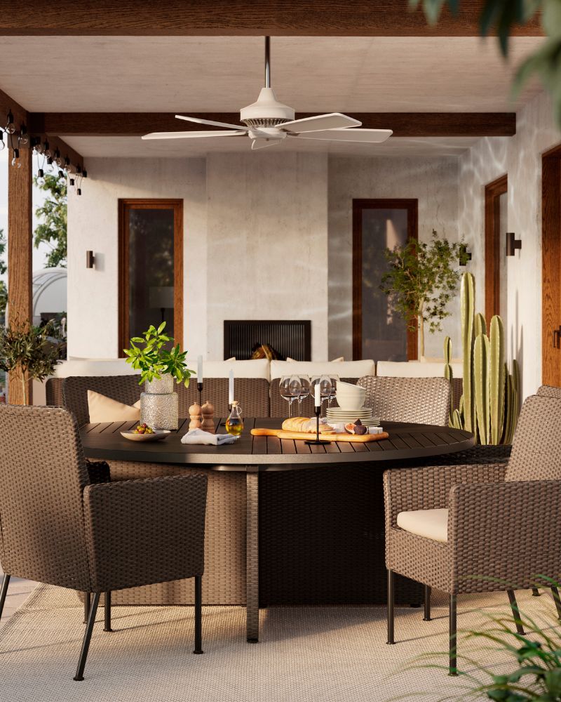 An outdoor dining setup in daylight, with six generous dark grey VITTSKÄR dining chairs and a matching round table.