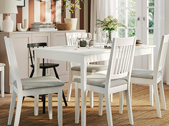 Mesa blanca con sillas en comedor luminoso.