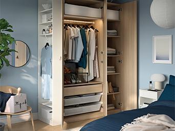 Armario de madera abierto en dormitorio con ropa organizada, cajones y estantes.