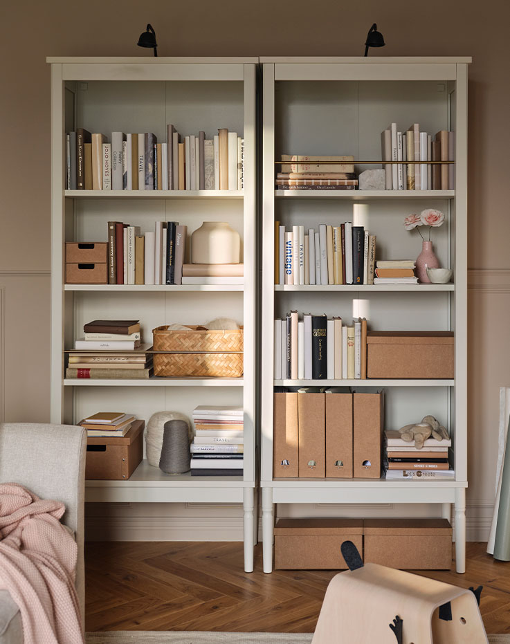 Two FÄRJKARL bookcases with books, GÄRDESGÅRD magazine files and boxes on the shelves and TVÄRDRAG cabinet lighting on top.