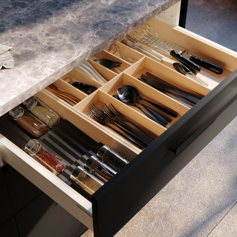 Organized kitchen drawer with TILLAGD cutlery, UPPDATERA utensil trays and VARDAGEN peeler neatly arranged.