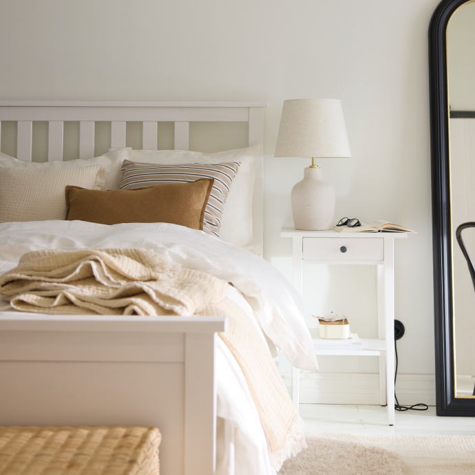 Dormitorio minimalista con cama blanca y lámpara de mesa