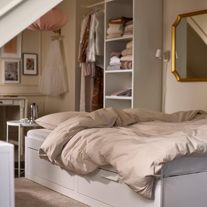 Dormitorio acogedor con cama con almacenaje y armario abierto