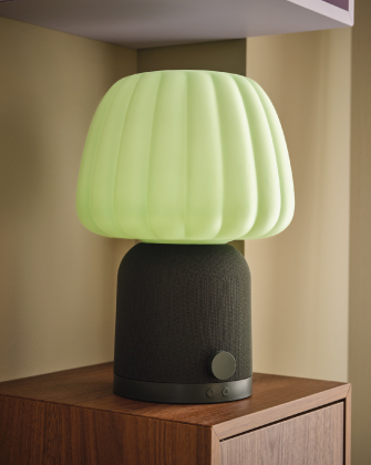 Lámpara de mesa moderna verde sobre un mueble de madera.