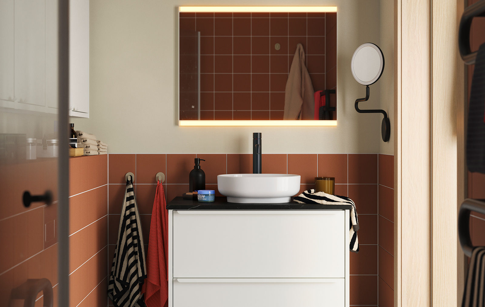 A terracotta-tiled bathroom with HAVBÄCK/VINDEÄLVEN washbasin cabinet in white, topped with a round basin and black tap.