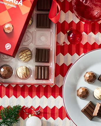 Surtido de pralinés VINTERSAGA de chocolate con diferentes formas y acabados, presentados en una bandeja y servidos sobre una mesa decorada para las celebraciones.