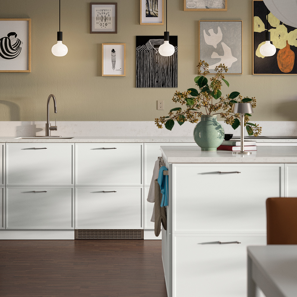 A medium-sized kitchen with a METHOD/MAXIMERAbase cabinet showing a white ASPUDDEN front drawers and doors. Also includes a light grey EKBACKEN countertop and a SALLSJÖN kitchen mixer tap. 