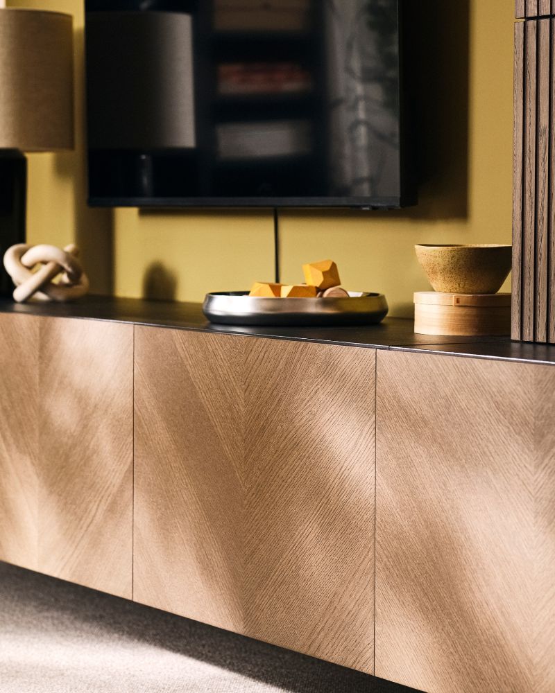 BESTÅ media storage combination with closed cabinets and decorative items beneath a TV in a living room.