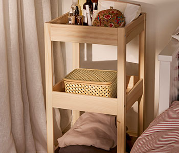 Beige VIELÅNGEN boxes in bamboo stand inside a shelving of the clear wood.