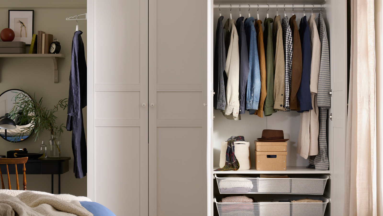 White open wardrobe with hanging clothes and organized drawers in a modern bedroom