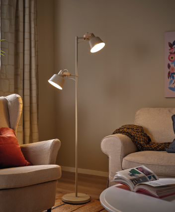 Sala acogedora con lámpara de pie encendida entre dos sillones.