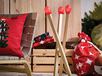 Decorative wooden matchstick-shaped lamps next to an armchair and Christmas decor.