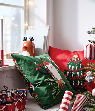 Holiday decorative pillows in green with Santa Claus and red with embroidered tree.