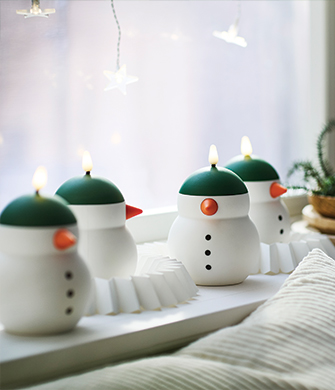 Snowman-shaped LED decorative candles lined up on a windowsill.