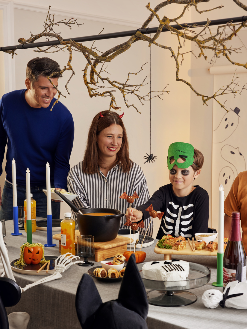 Fiesta de Halloween con mesa decorada y disfraces.
