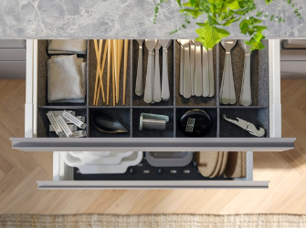 Cajón de cocina organizado con cubiertos y utensilios.